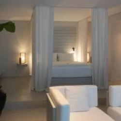 Luxury suite at The Lombok Lodge, featuring soft ambient lighting, elegant white decor, and a luxurious canopy bed for the ultimate relaxation experience