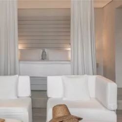 A beautifully designed luxury suite at The Lombok Lodge, featuring elegant white interiors, a cozy king-size bed, and a stylish seating area for ultimate luxury relaxation