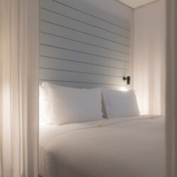 Elegant white canopy bed in a luxury Lombok suite for babymoon stays