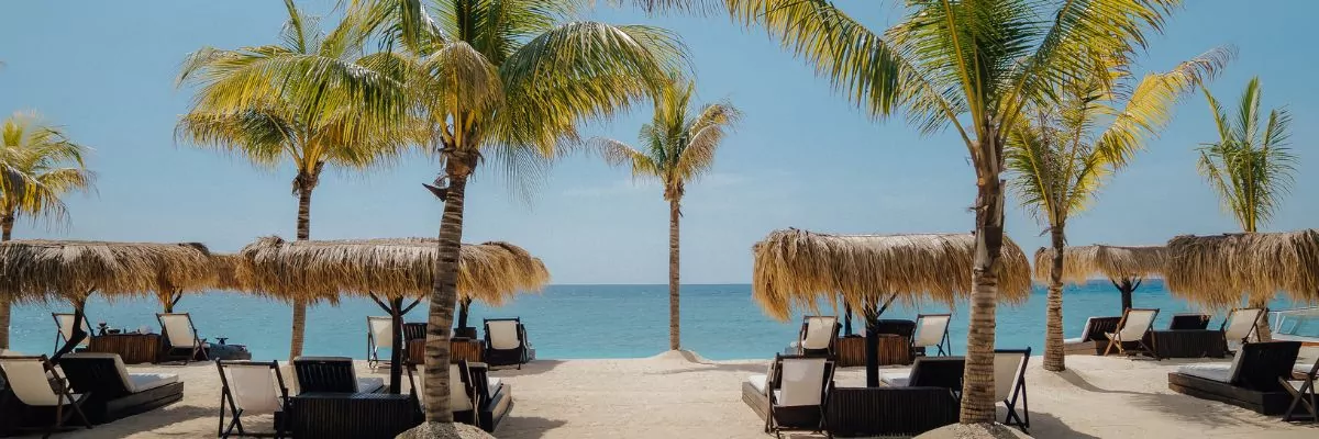 Romantic beachfront setting in Lombok with palm trees, luxury sunbeds, and turquoise ocean – perfect for an anniversary getaway