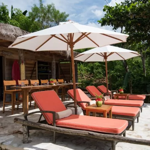 Sun loungers with umbrellas at a beachfront villa, Nihi Sumba Resort